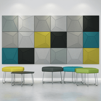 Colorful Acoustek Cavasinni acoustic tiles displayed on a wall with modern seating options beneath.