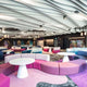 Modern lounge area featuring colorful seating and acoustic ceiling design for enhanced sound absorption and aesthetics.