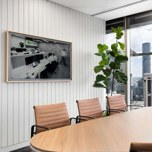 Modern office meeting room featuring acoustic panels, stylish decor, and a large window with city view.